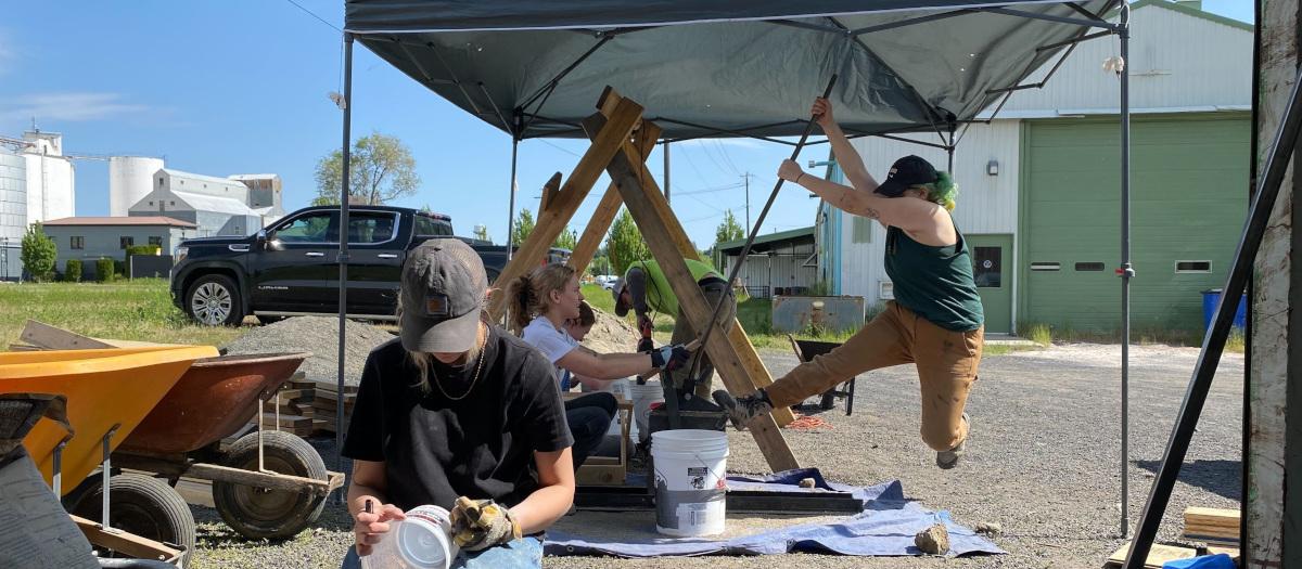 Photo of students under pop up tent making bricks